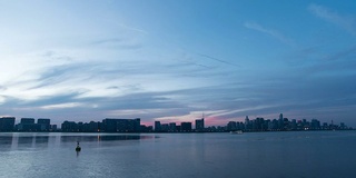 日落时的天空、河流和现代建筑。时光流逝。