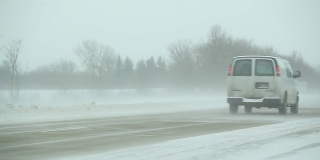 冬季暴风雪与吹雪横跨高速公路，扫雪机和车辆