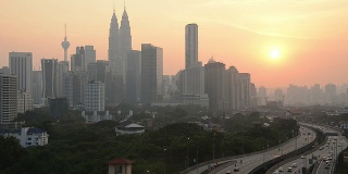 日落时分，吉隆坡的天际和高架路上繁忙的交通。
