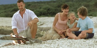 一家人在岛上的沙滩上，火炉边唱歌