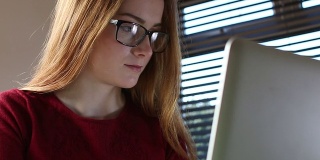上网学习笔记本电脑，年轻女子戴眼镜。多莉。