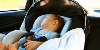 高清:一个小男孩在车里睡觉的照片。