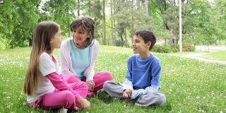 年轻妇女和孩子们在绿色公园讨论。