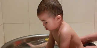 宝宝在洗澡的时候玩碎石鸭