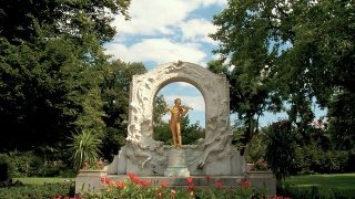 在风景如画的公园里，音乐家的金色雕像- zoom视频素材模板下载