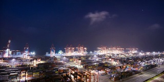 夜间港口繁忙的起重机装载集装箱，时间流逝。