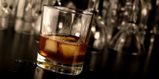 将威士忌和冰倒入玻璃杯中