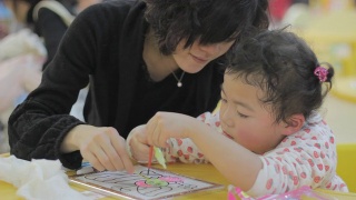 妈妈，亚洲女孩在幼儿园配合涂色画。视频素材模板下载