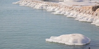 海岸边的石墩上，覆盖着白雪