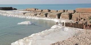 海岸线共享码头，土地覆盖着白雪和海浪