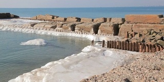 海岸线共享码头，土地覆盖着白雪和海浪