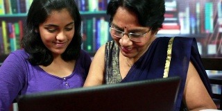 印度老妇人和她的孙女争抢笔记本电脑