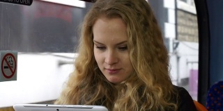 年轻女子在公车上拿着平板电脑
