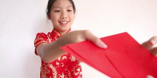 春节快乐。微笑的亚洲女孩拿着红包