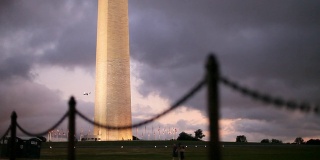 日落时分华盛顿纪念碑旁的跑步者