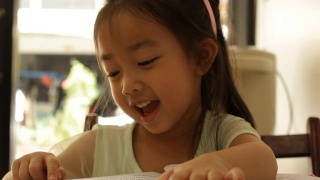 亚洲可爱的小女孩在看书视频素材模板下载