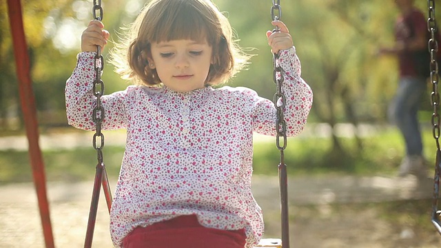 小女孩在公园荡秋千