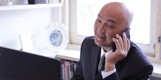一位亚洲企业高管在用手机聊天