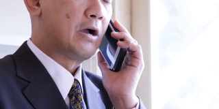 一位亚洲企业高管在用手机聊天