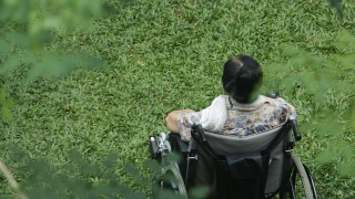 坐在轮椅上的亚裔老年妇女视频素材模板下载