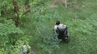 亚洲资深妇女寻找一个人在她的轮椅上视频素材模板下载