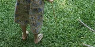 亚洲高级妇女拿着拐杖寻找某人