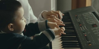 一位中国母亲教她的儿子弹钢琴