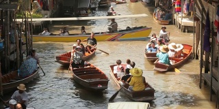 在Damnoen Saduak水上市场，木船忙着运送人