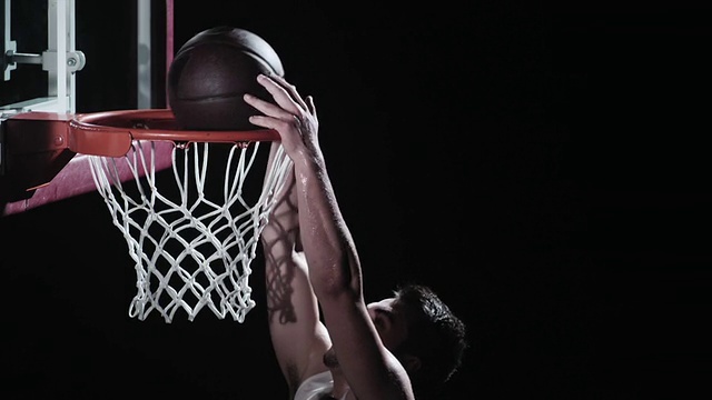 一个篮球运动员把球灌入篮筐的SLO动作
