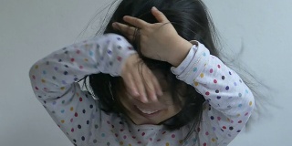 一个中国小女孩做鬼脸的慢镜头特写