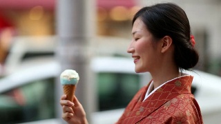 穿着和服的日本女孩在涉谷吃冰淇淋视频素材模板下载