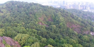 近现代城市的绿色山丘鸟瞰图，实时。