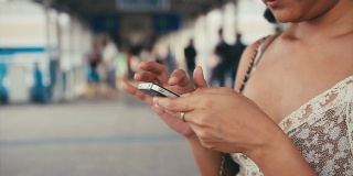 一名亚洲女性在城市场景中通过智能手机阅读信息