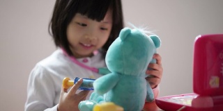 亚洲华人幼童玩假装医生与她的泰迪熊的特写