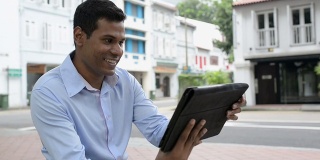 兴高采烈的印度商人在户外使用数字平板电脑