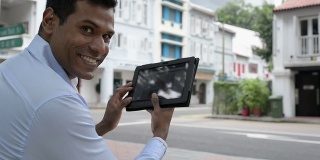 兴高采烈的印度商人在户外使用数字平板电脑