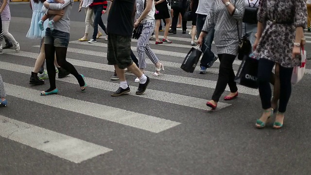 行人在城市街道斑马线上行走，实时。