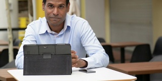 印度商人在户外咖啡馆使用数字平板电脑