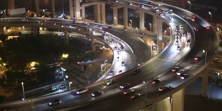 夜间高架路口的天际线和繁忙的交通，实时显示。