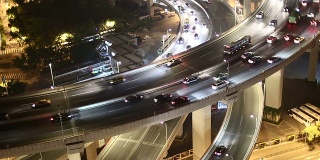 夜间高架路口的天际线和繁忙的交通，实时显示。