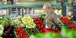 年轻的金发女人在买蔬菜