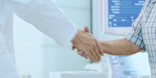 高级妇女和她的医生在办公室握手