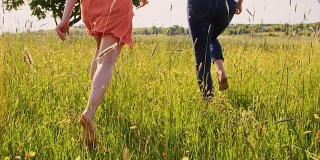 妈妈和女儿赤脚在草地上跑步