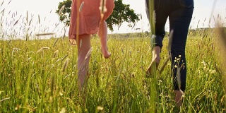 快乐的女人和女孩赤脚在草地上奔跑