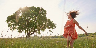 快乐的女孩赤脚在草地上奔跑