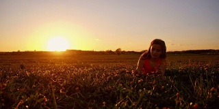 日落时分，女孩在草地上吹蒲公英