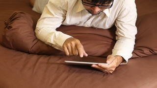 商人在床上用数字平板电脑工作视频素材模板下载