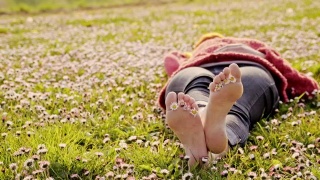 一个躺在雏菊丛中的女人视频素材模板下载