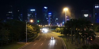 随着时间推移，深圳夜间多车道高速公路和建筑物上的繁忙交通。