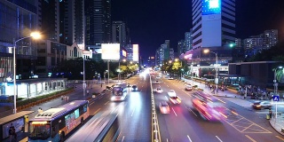 随着时间推移，深圳夜间多车道高速公路和建筑物上的繁忙交通。